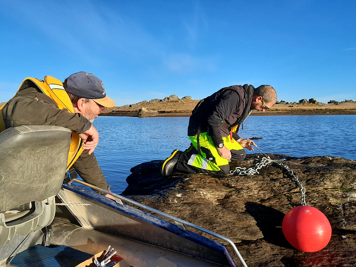 Otago Fish & Game officer Steve Dixon (left) and ORC deputy harbourmaster Pete Dryden attach a marker buoy to a rock at Poolburn Dam. PHOTO: BEN SOWRY, OTAGO FISH & GAME