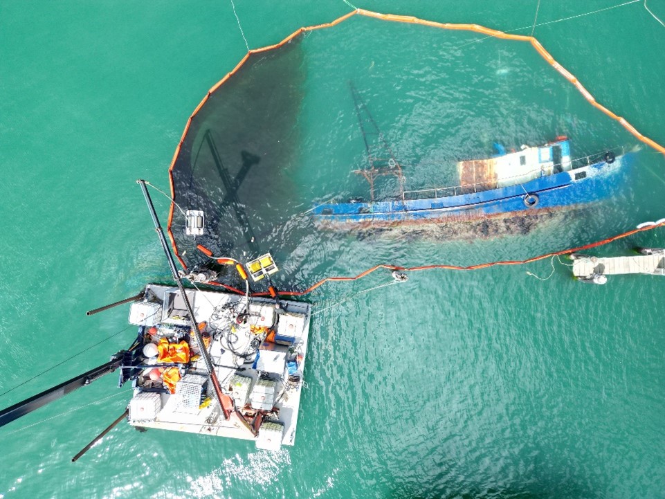 oily water to be skimmed with two mechanical skimmers can be seen within the boom