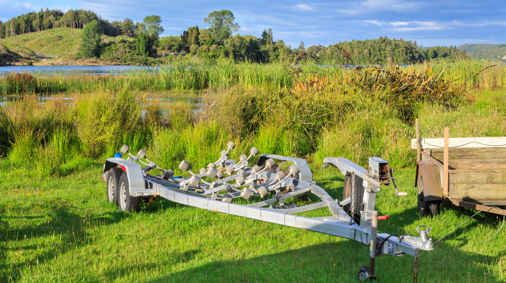 Metal Boat Trailer On The Grassy Shore Of A Lake Adobestock 341294365