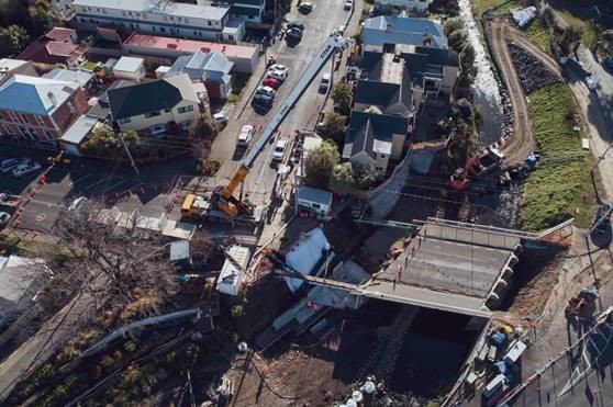 a partially constructed bridge with a crane lifting materials