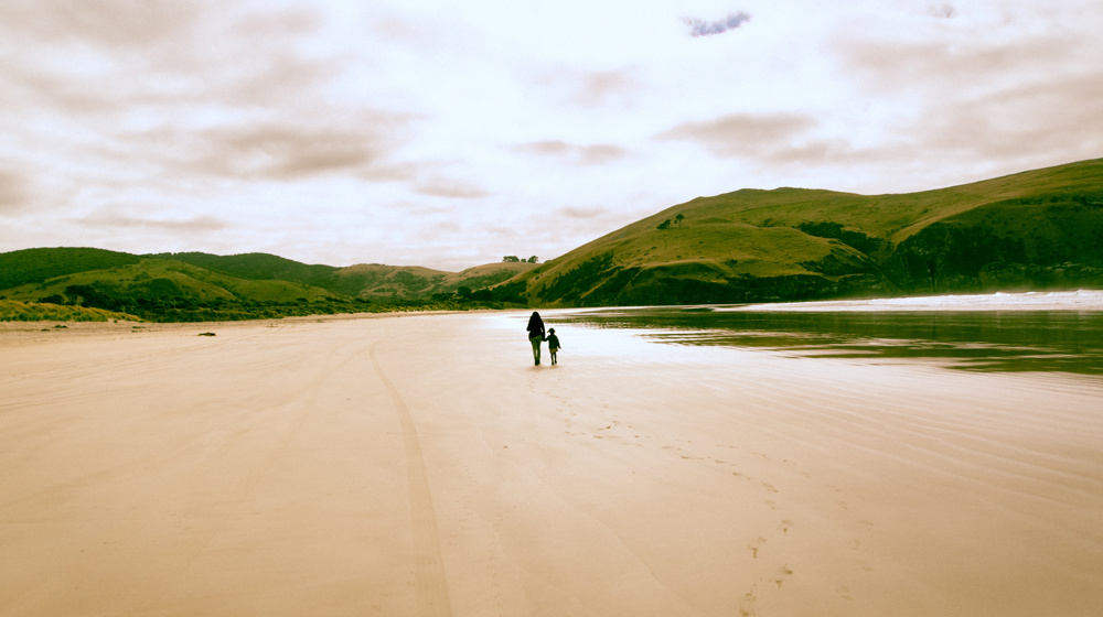 Mother And Child Walking On Quiet Otago Beach Adobestock 1863334373
